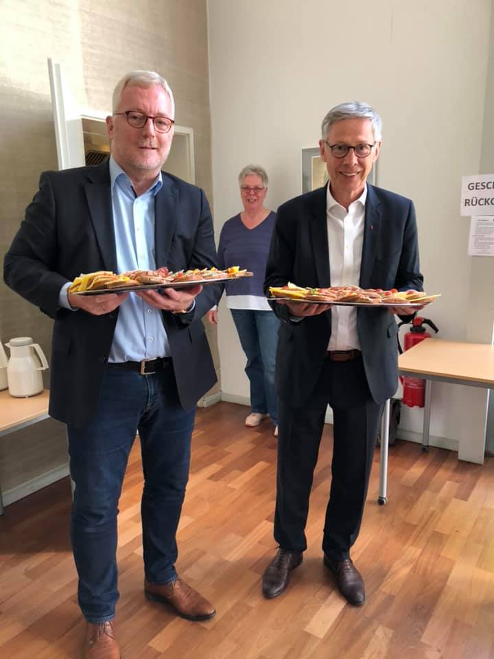 Manfred Meyer und Carsten Sieling verteilen Brötchen im Café Mittwoch der Gemeinde Horn.